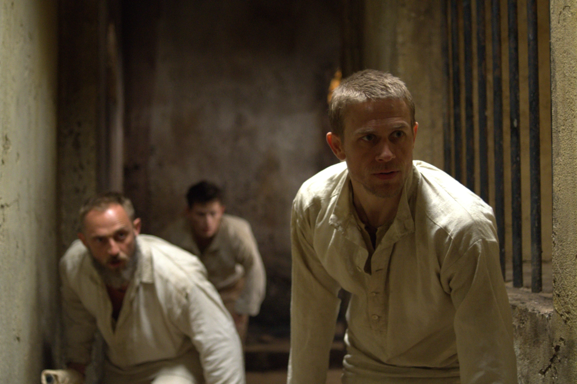 Charlie Hunnam, Joel Basman, and Roland Møller in Papillon (2017)