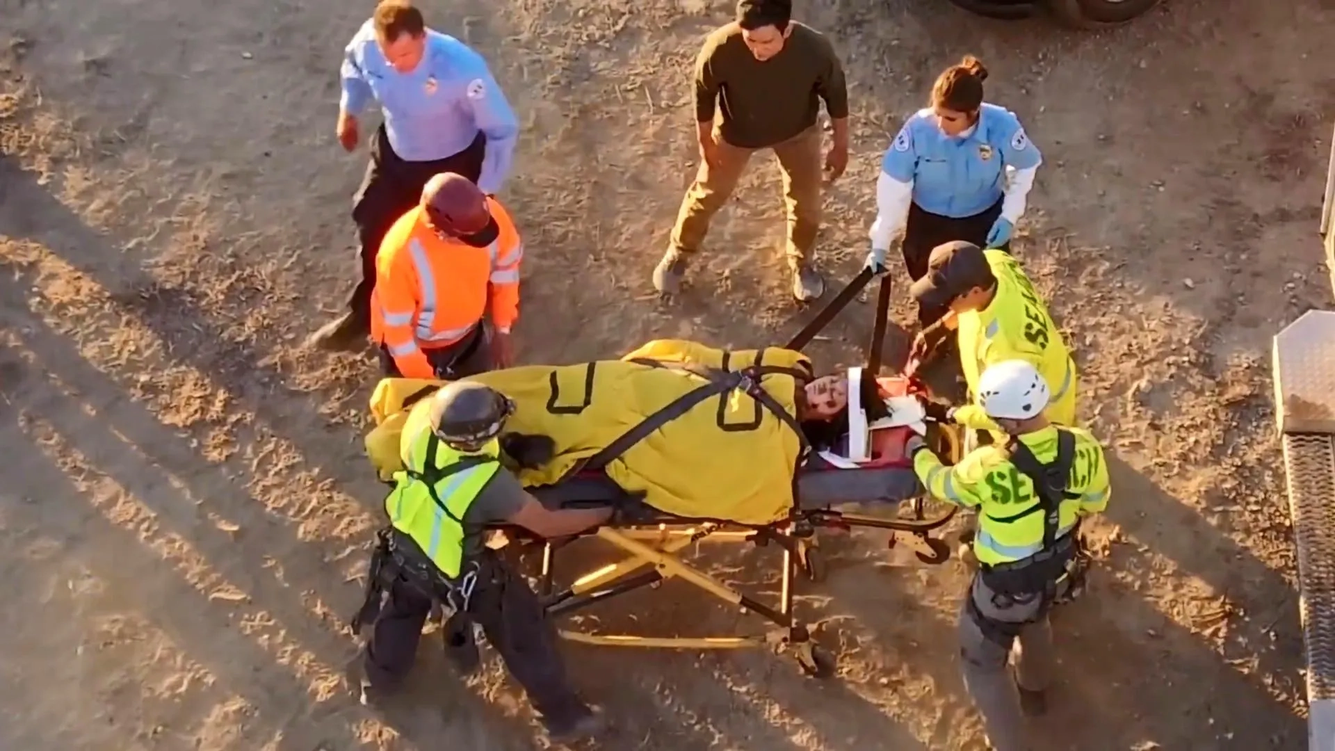 David (John Cho) stands by as rescuers help an EMT (Rene Michelle Aranda) secure Margot (Michelle La) to a gurney in a still from Searching.