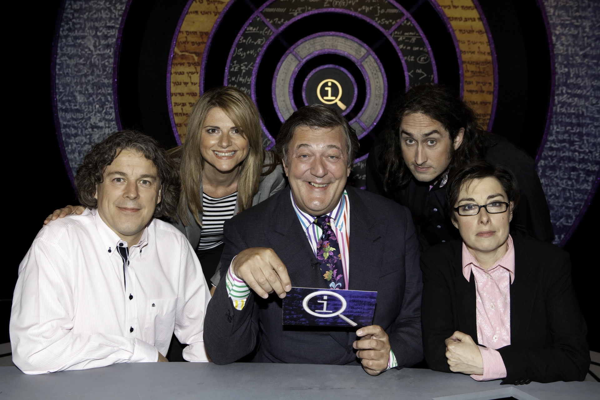 Stephen Fry, Alan Davies, Ross Noble, Sue Perkins, and Julia Zemiro in QI (2003)